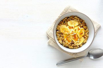 Oatmeal with banana against white table