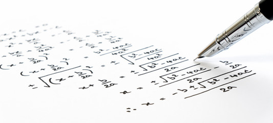 Handwriting of mathematics quadratic equation formula on examination, practice, quiz or test in...