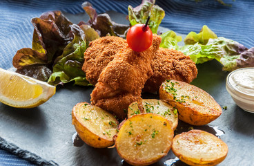 Fish in batter with potatoes and vegetables