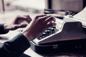 Close up man typing on an antique vintage typewriter machine