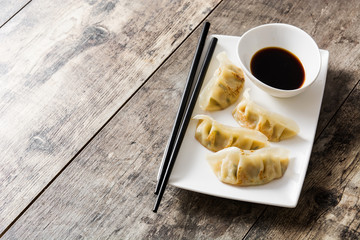 Dumplings or gyoza and soy sauce on wooden table. Copyspace