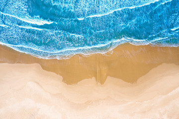 Fototapeta na wymiar Vista aerea di una spiaggia con mare azzurro e onde