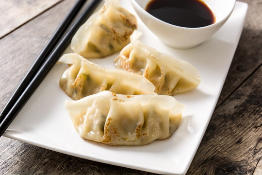 Dumplings or gyoza and soy sauce on wooden table. Close up