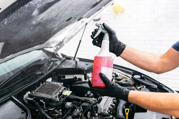 Plakat Cars in a carwash. Car wash with foam at station. Carwash. Washing at the station. Car washing concept. Car detailing. A man cleaning car. Worker cleaning. Cleaning engine with the foam and a brush