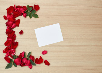 red roses petals and white blank paper