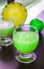 Pineapple and apple green smoothie. Healthy food. Fresh juicy breakfast concept. Dark wooden background.