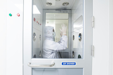A scientist in sterile coverall gown using air shower
