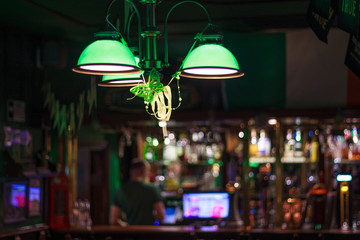 Irish pub inside. Photo of the bar of a green dark bar. focus on the chandelier.