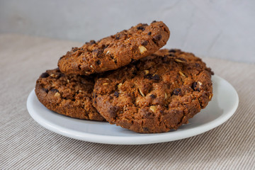 Chocolate chip cookies on white background. Stacked chocolate chip cookies on brown napkin. Symbolic image with place for text. Freshly baked. Concept for a tasty snack. Sweet dessert. 