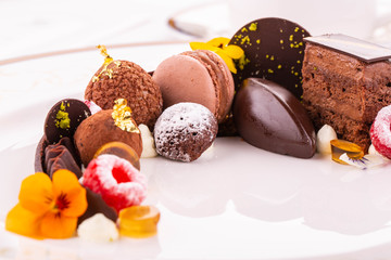 Chocolate desserts with icing sugar, berries and gold