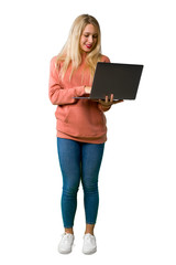 A full-length shot of a Young girl with laptop on isolated white background