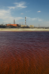 Lake with toxic waste on a background of chimneys copper smelting plant.