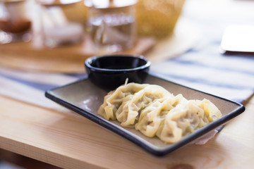 Gyoza with a cup of sauce. In the plate ready to eat In the warm kitchen.