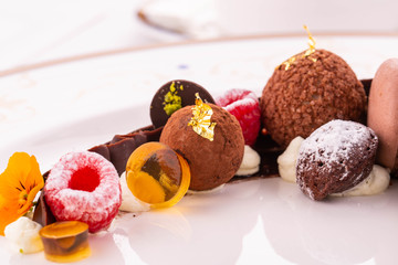 Handmade chocolate truffle with fruit jelly and raspberry in icing sugar