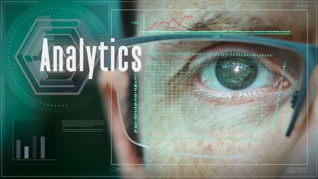 A close up of a businessman eye controlling a futuristic computer system with an Analytics concept.