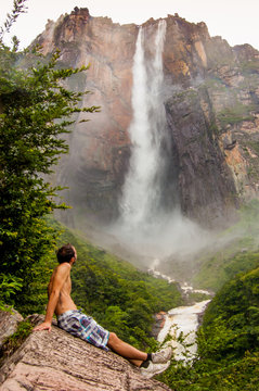 view from below forest of angel falls in venezuela in canaima park, with tourist watiching, giving a sense of discovery and awe