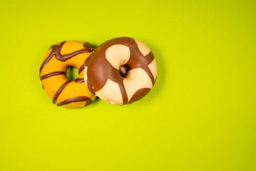 Various decorated doughnuts isolateds on a green background isolateds. Sweet and colourful doughnuts