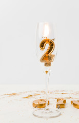 champagne glass and golden 2019 numbers with burning candle on white