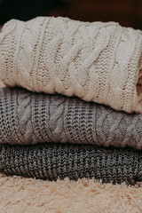 knitted sweaters on a soft peach carpet close-up