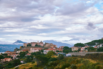 Fototapeta premium View of Citadel of Calvi during the cloudy day with mountains in the background