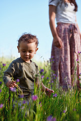 Adorable child in field of flowers with mum