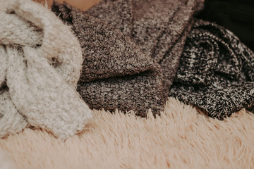 Background with warm sweaters. Pile of knitted clothes, warm background, knitwear, space for text, autumn winter concept.