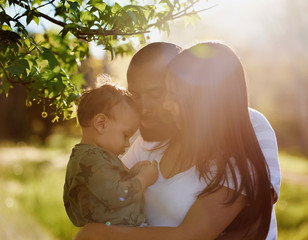 Loving family in park with sun flare