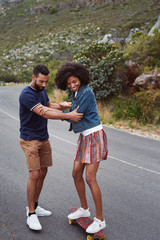 Couple having fun skateboarding outdoors