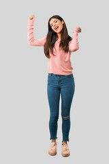 Full body of Teenager girl with pink shirt enjoy dancing while listening to music at a party on isolated grey background