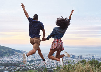 Couple jumping overlooking the city