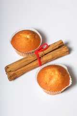 Fresh tasty muffins. Nearby are cinnamon sticks. On a white background.