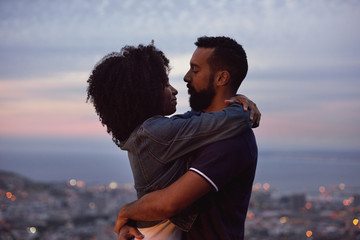Romantic couple hugging with city lights