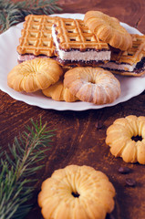 Plate with fresh cookies on dark wooden board. Top view.