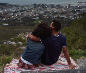 Backview of couple enjoying looking down at cityscape