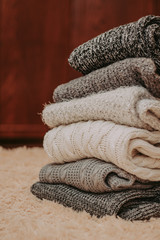 knitted sweaters on a soft peach carpet close-up