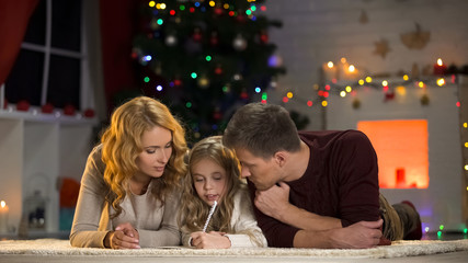 Happy family writing wishlist for winter holidays, planning X-mas celebration
