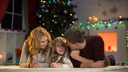 Family writing wishlist for winter holidays, planning Christmas celebration