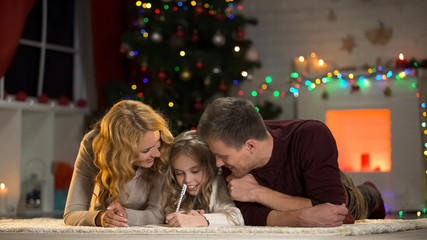 Family writing Christmas wishlist, planning holiday celebration, happy together
