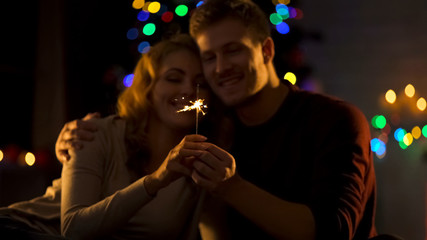 Romantic couple looking at Bengal light, making wish on Christmas, miracle