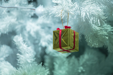Decorated gift on  white Christmas tree closeup.ball and gift Christmas eve seasonal.