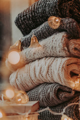 A bunch of sweaters, light bulbs, lanterns, cozy winter interior details, home decor and comfort.