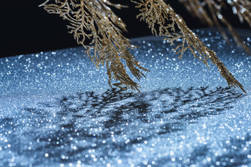 selective focus of festive branch decorated by golden glitter and shadow, christmas background concept