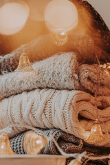 Fototapeta na wymiar A bunch of sweaters, light bulbs, lanterns, cozy winter interior details, home decor and comfort.