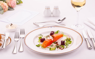 Fish cold appetizer, is served with a white glass of wine, vegetables and cottage cheese