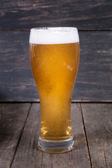 lager draft beer in a glass on dark wooden table