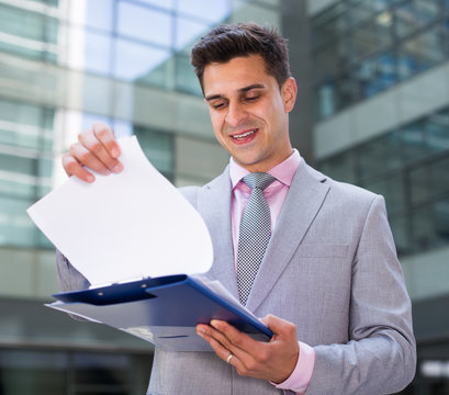 Businessman contentedly reading documents