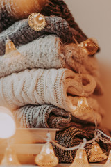 A bunch of sweaters, light bulbs, lanterns, cozy winter interior details, home decor and comfort.