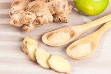 Ginger root and ginger powder on wooden background
