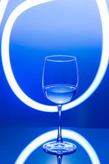 Drink at bar in a night time, wine glass with white wine and freeze light on a background. New year party drink.