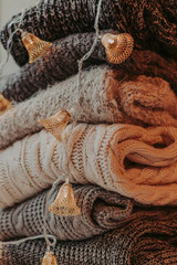 A bunch of sweaters, light bulbs, lanterns, cozy winter interior details, home decor and comfort.